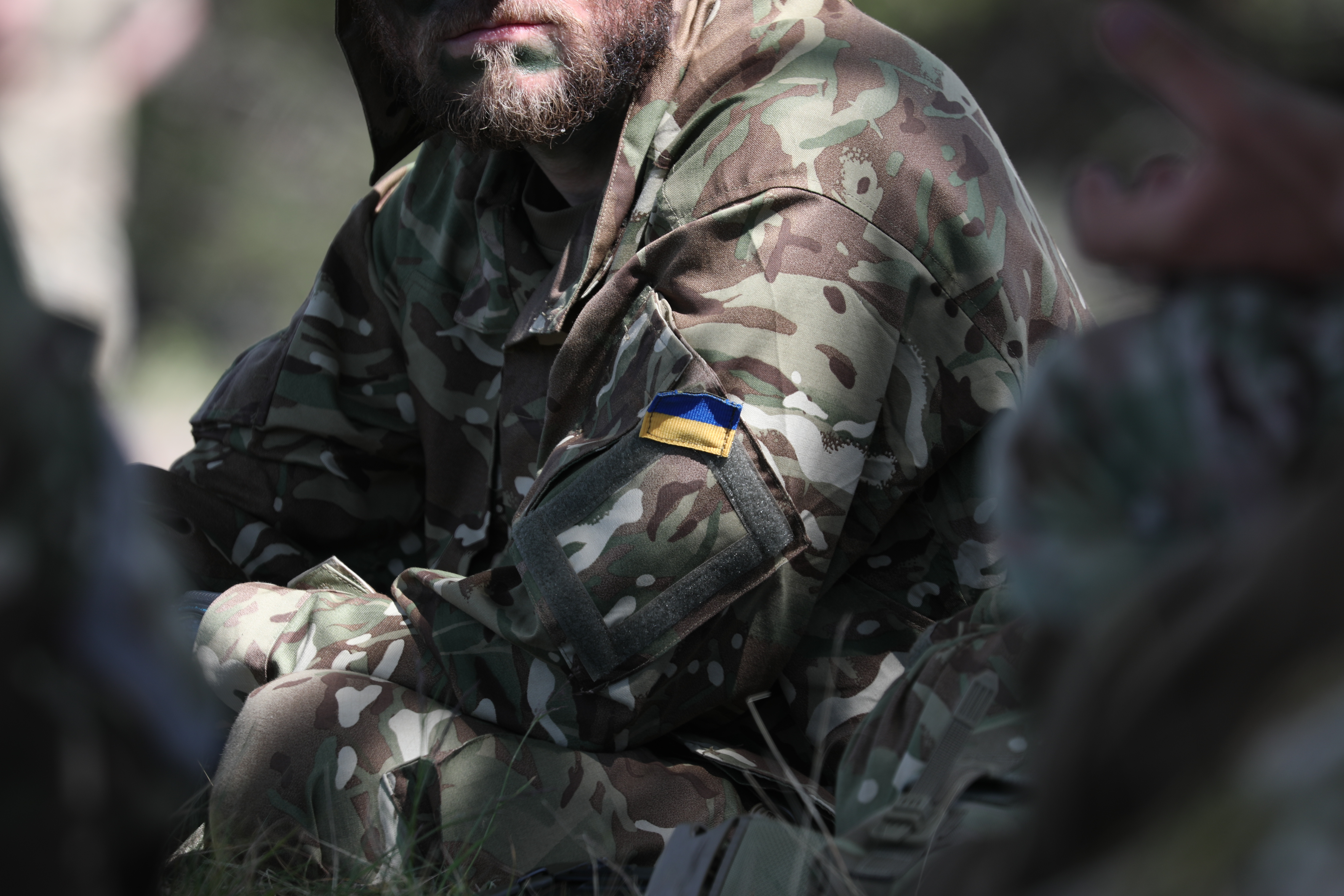 Image shows personnel with Ukrainian flag on shoulder. 